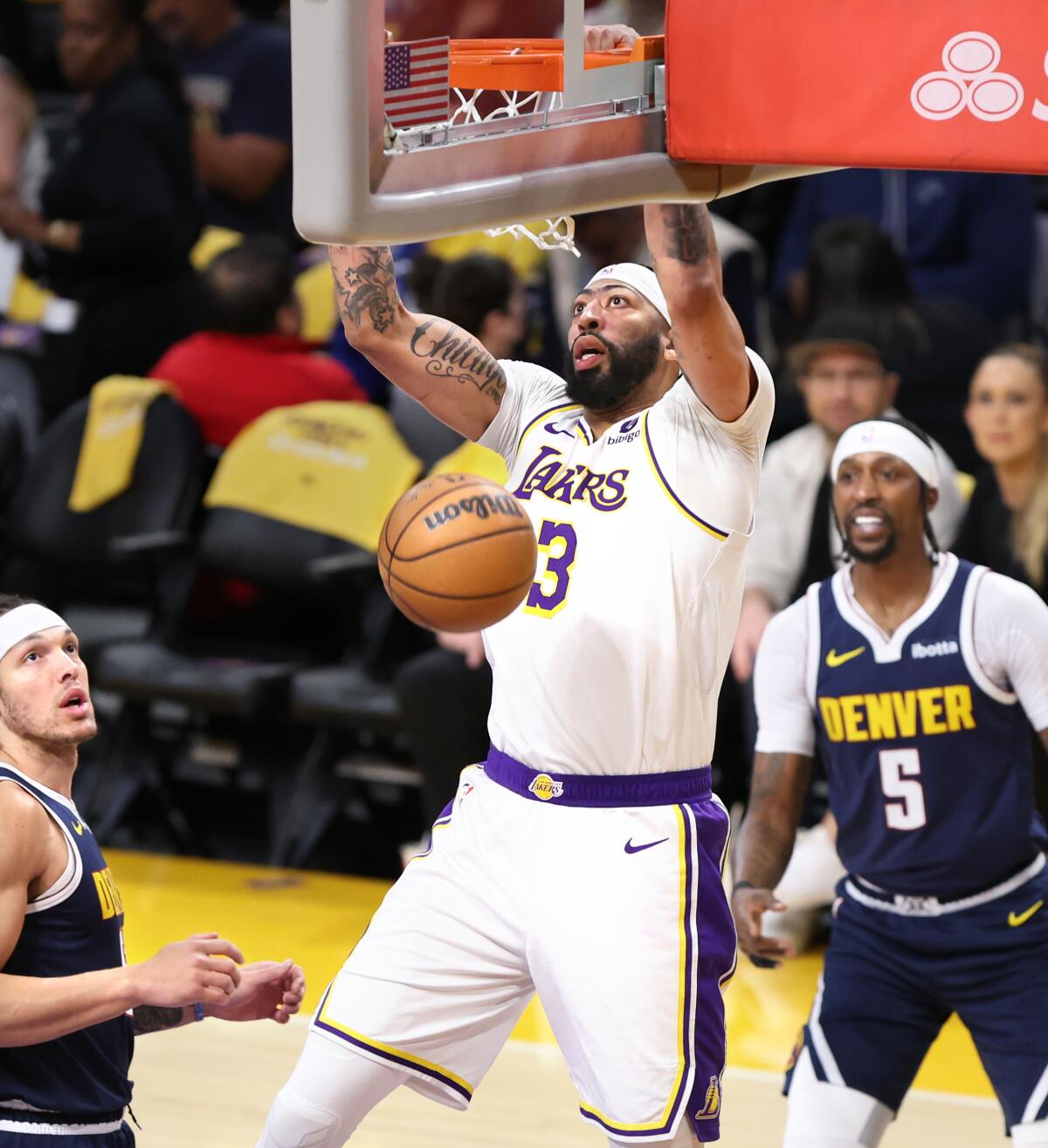 Lakers forward Anthony Davis dunks over Nuggets forward Aaron Gordon, left, and guard Kentavious Caldwell-Pope.