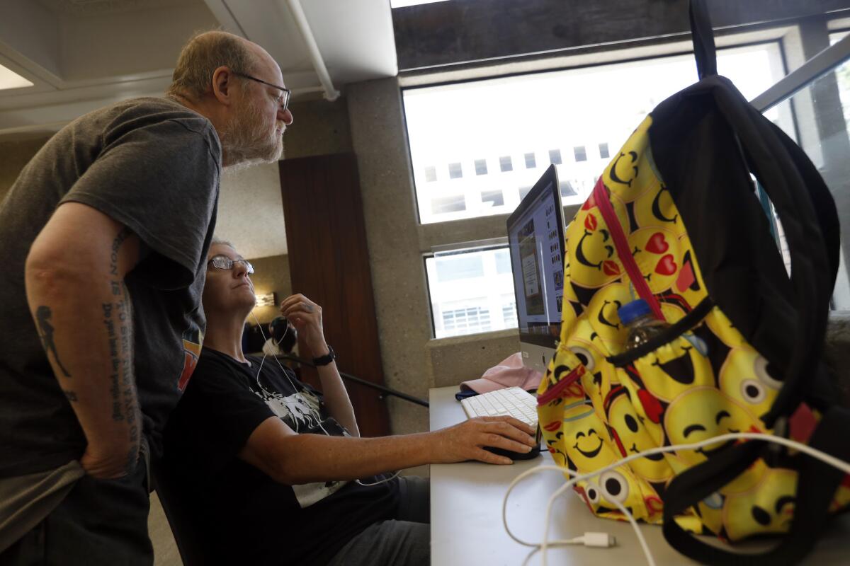 Larry Wynne, left, and his wife, Tess, who are both 55 and homeless, spend part of their day at the Glendale Central Library.