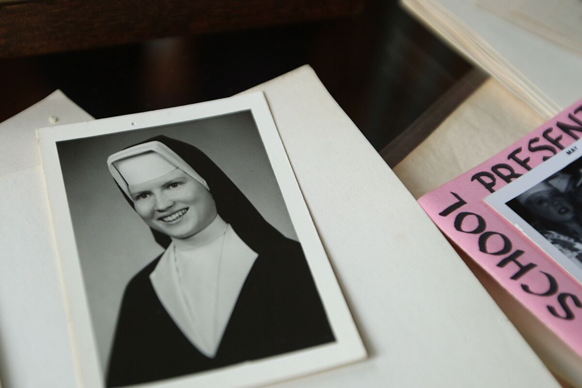 A black-and-white photo of a nun among sheets of paper