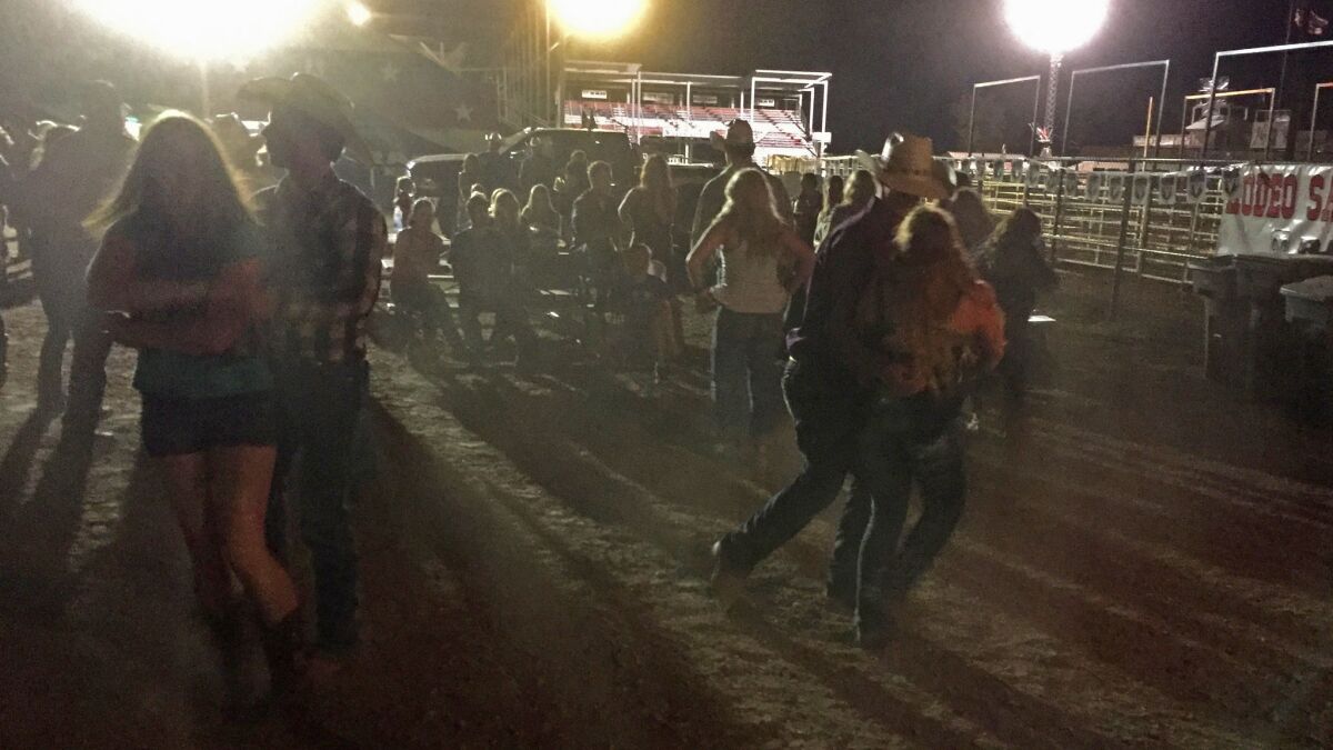 At the end of a rodeo night in Belle Fourche, S.D., young cowboys and cowgirls dance in the darkness and dust.