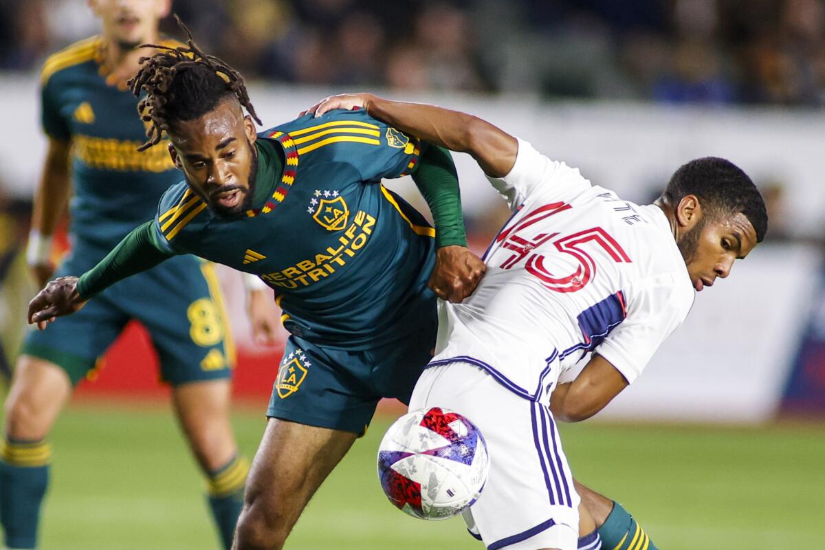 Galaxy forward Raheem Edwards, left, and Vancouver Whitecaps midfielder Pedro Vite fight for the ball.