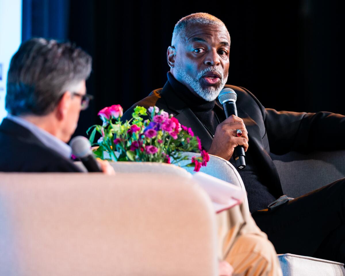 LeVar Burton and Times editor Steve Padilla hold microphones and sit in chairs.