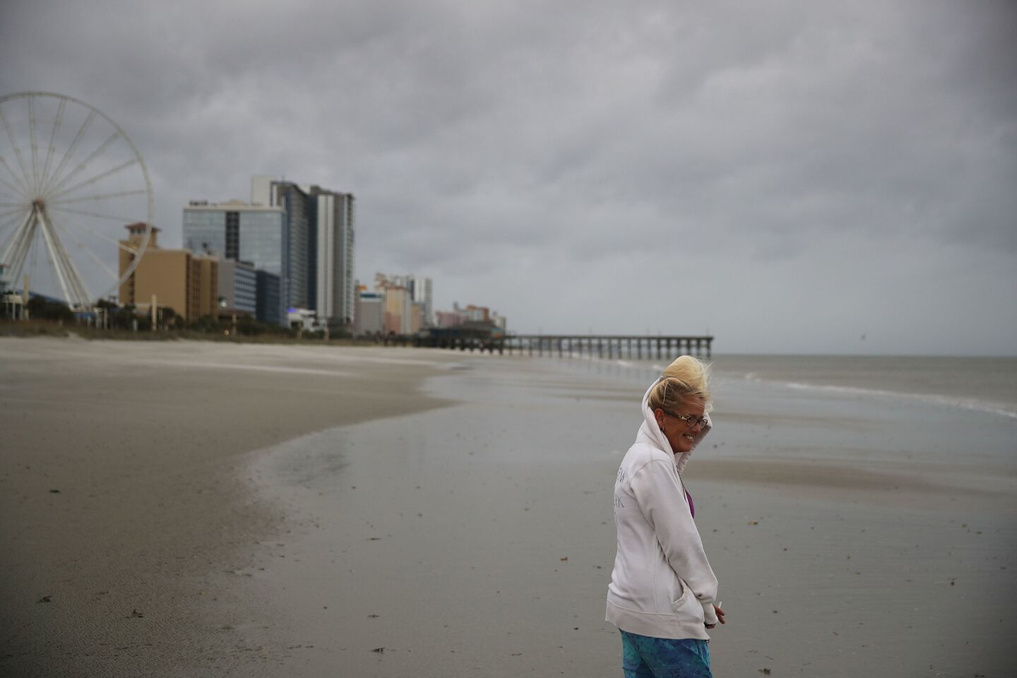 Linda Deem walks along the beach as winds from Hurricane Florence are felt in Myrtle Beach, S.C