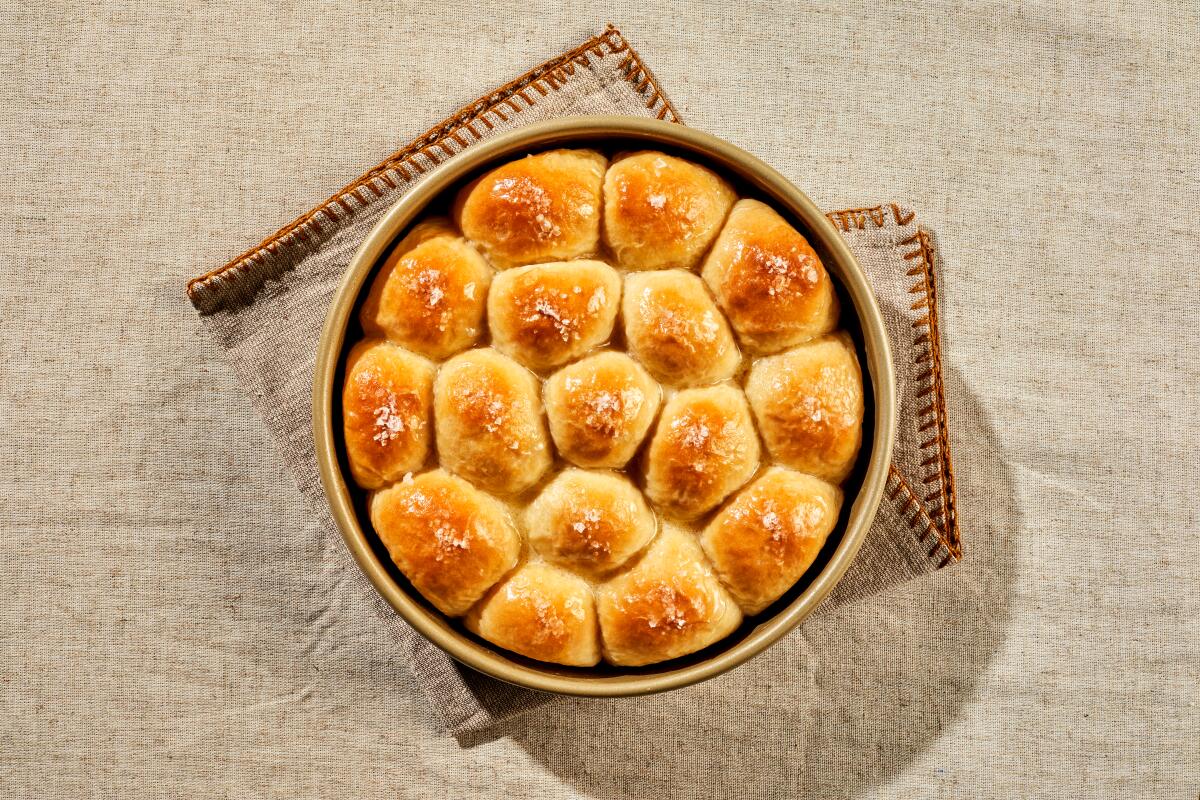Overhead view of a round baking dish with dinner rolls. 