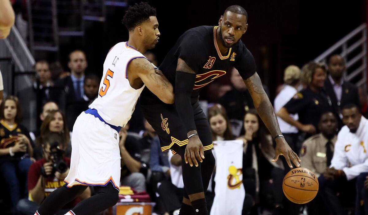 Cleveland Cavaliers' LeBron James, right, handles the ball against New York Knicks' Courtney Lee in the first quarter Tuesday.