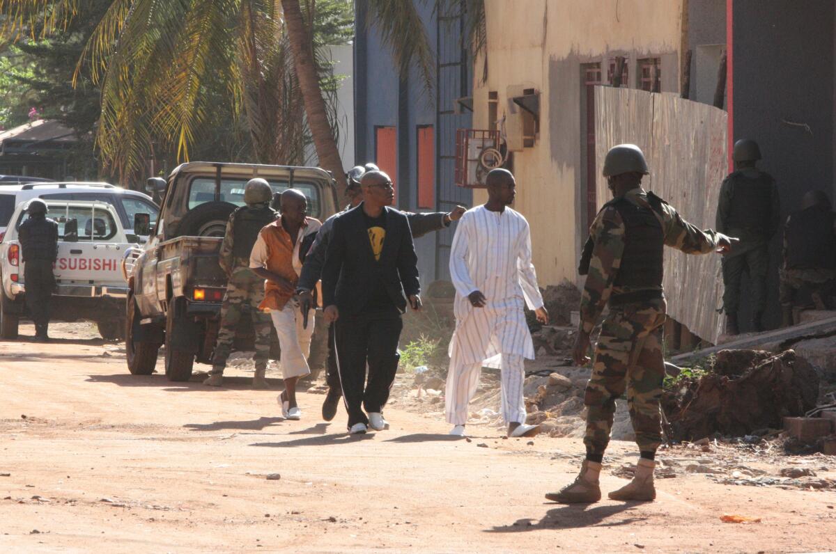 En la imagen, personal de seguridad escolta a personas que huyen del hotel Radisson Blu en Bamako, Mali, el viernes 20 de noviembre de 2015, donde varias personas lanzaron un ataque y tomaron rehenes.