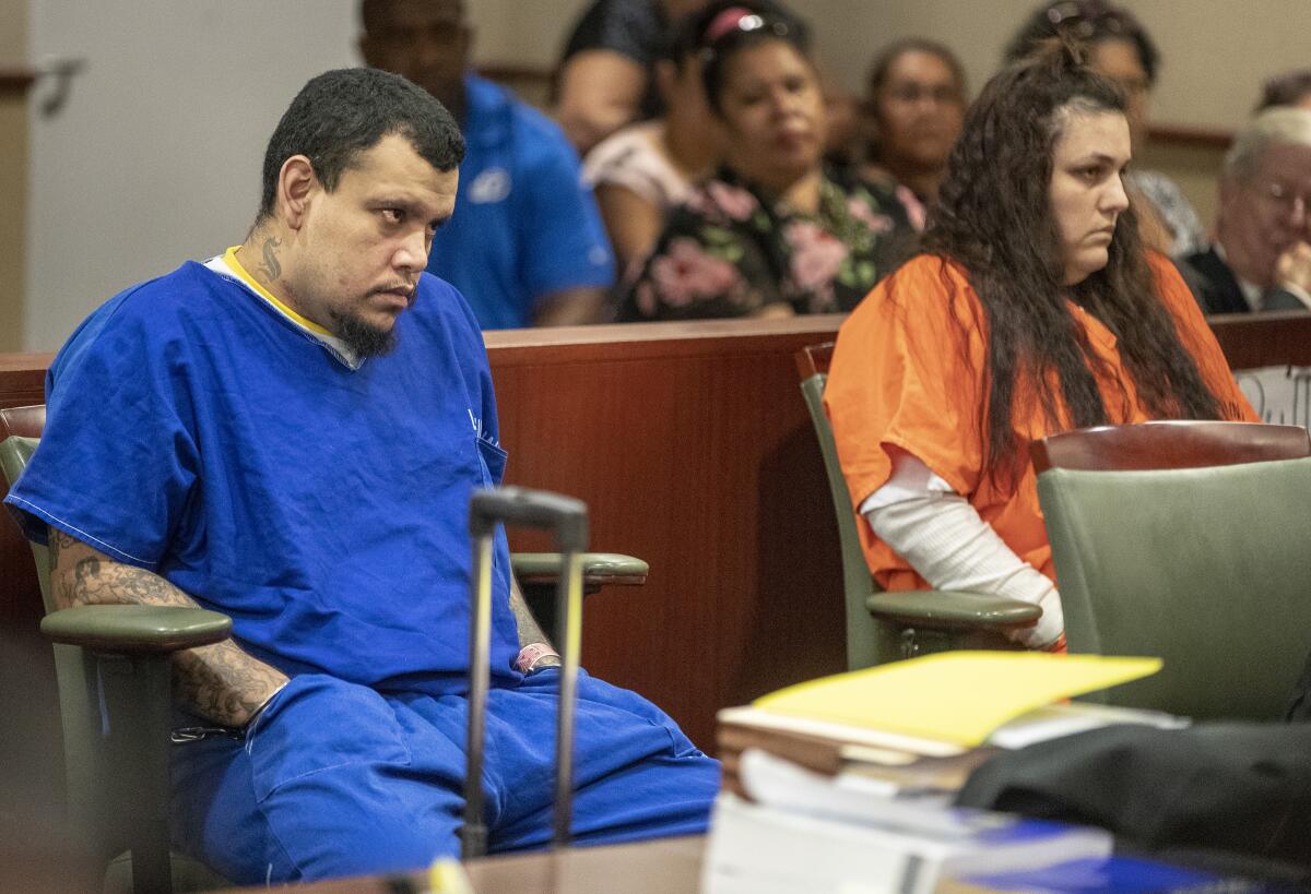 Heather Barron, right, and her boyfriend Kareem Leiva, left, sit in  a courtroom.