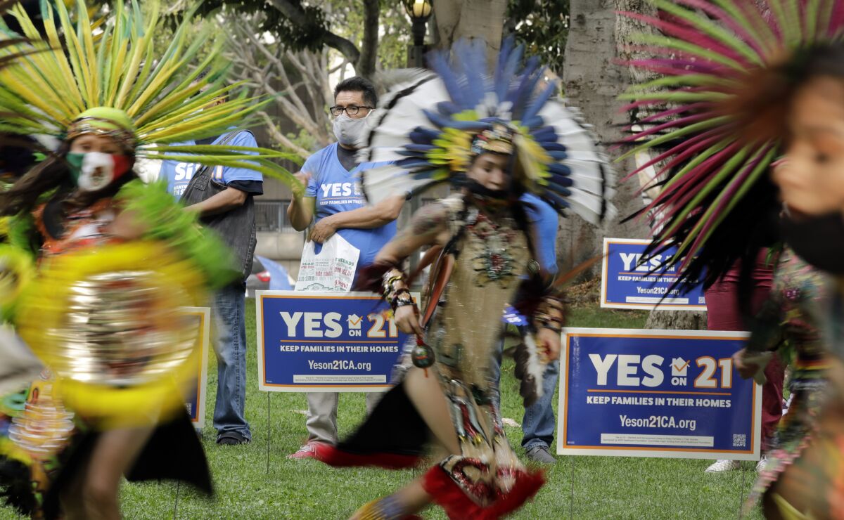 The dance troupe, Danza Azteca Chichimeca, entertains during the "Celebrate Renters Rally" in support of Proposition 21.