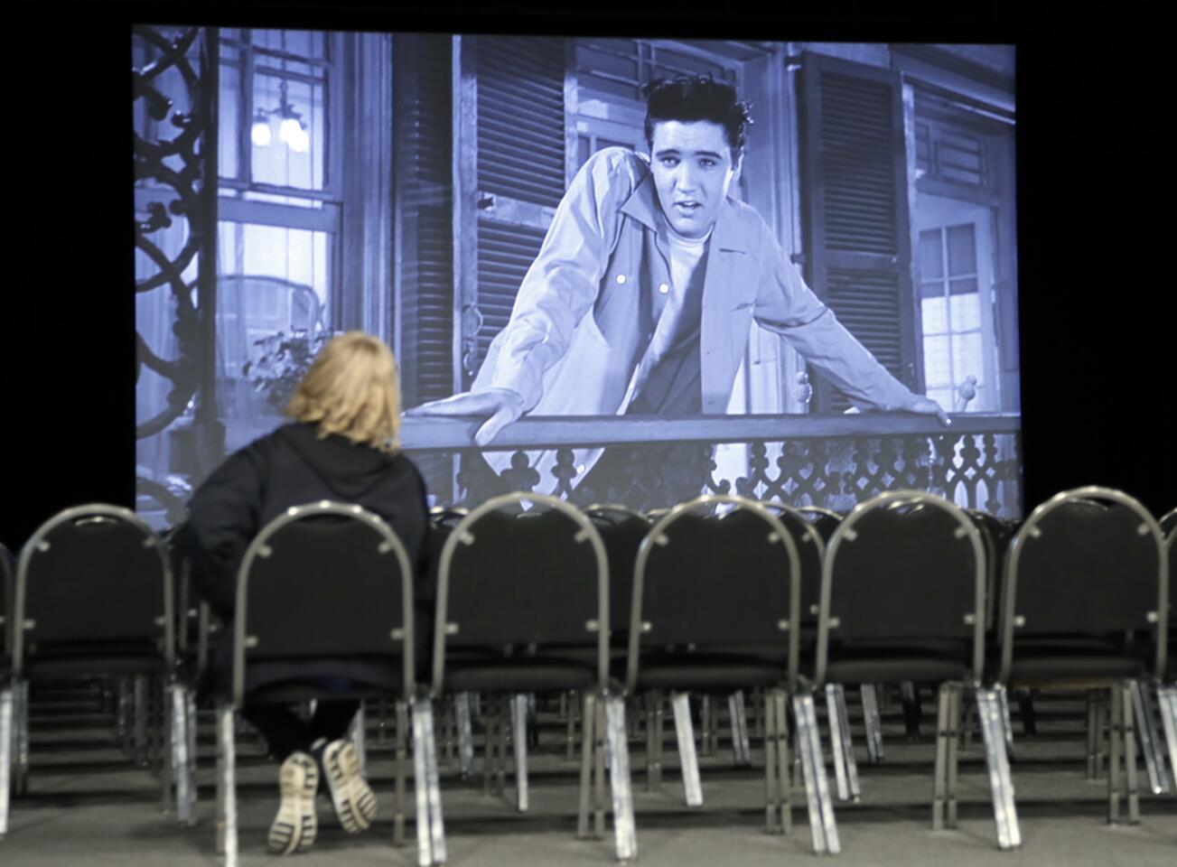 A woman watches the Elvis Presley film "King Creole" in a theater in the "Elvis Presley's Memphis" c