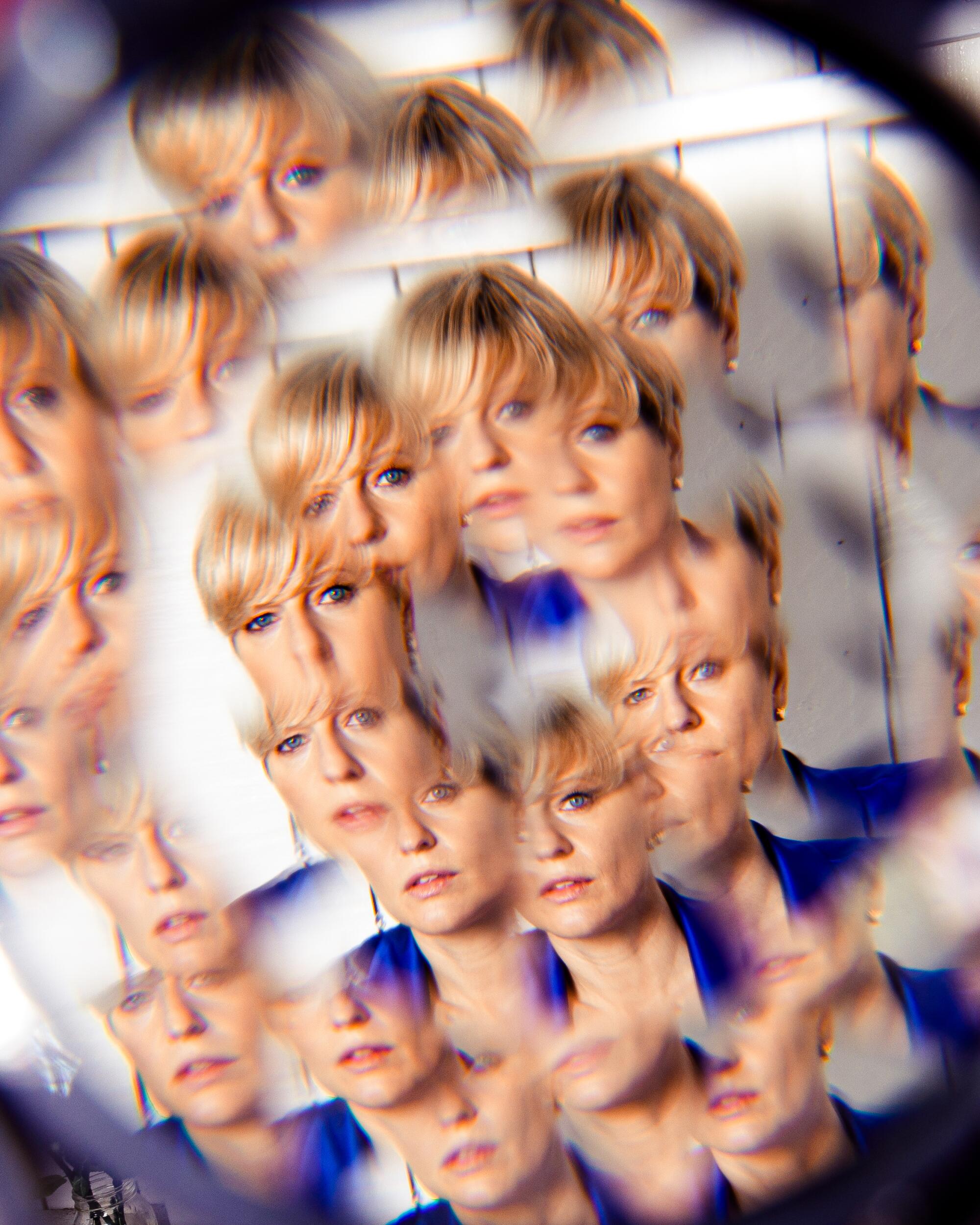 A woman viewed through a kaleidoscope-like lens.