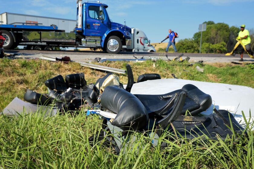 Workers clear debris from westbound Interstate 70 on Wednesday, July 12, 2023, after a Greyhound passenger bus collided with a tractor-trailer near Highland, Ill. (Christian Gooden/St. Louis Post-Dispatch via AP)