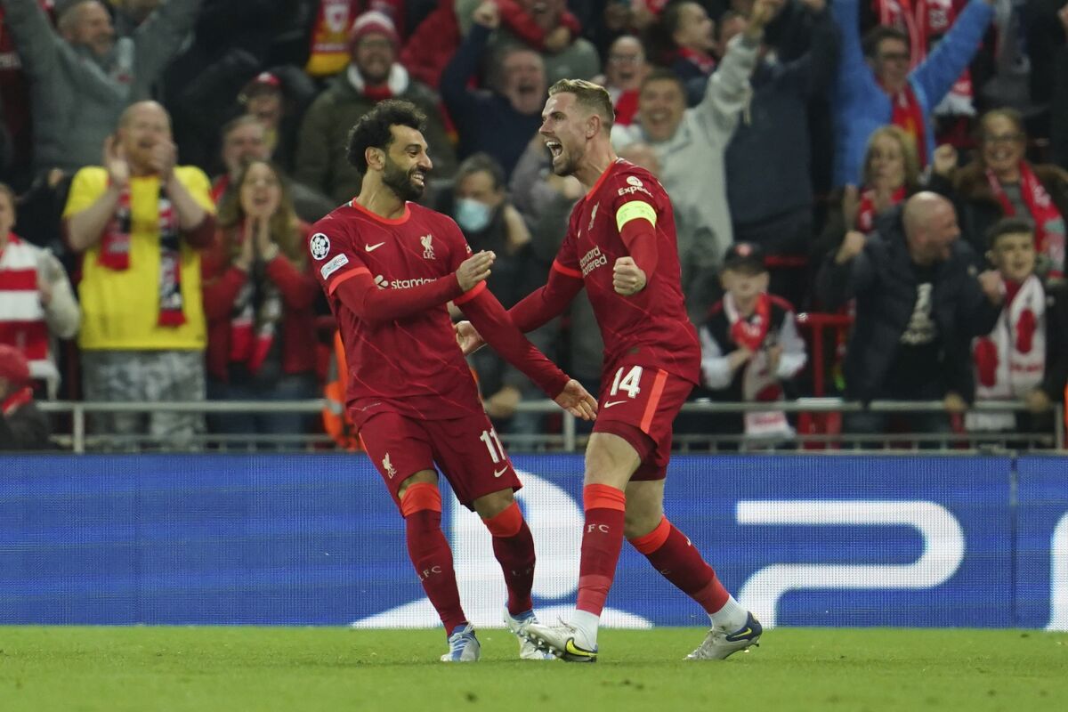 Liverpool's Jordan Henderson, right, celebrates with his teammate Mohamed Salah after Villarreal's Pervis Estupinan scored an own goal during the Champions League semi final, first leg soccer match between Liverpool and Villarreal at Anfield stadium in Liverpool, England, Wednesday, April 27, 2022. (AP Photo/Jon Super)