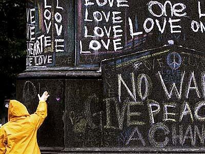 A New York city worker rubs chalked graffiti off a monument in Union Square.
