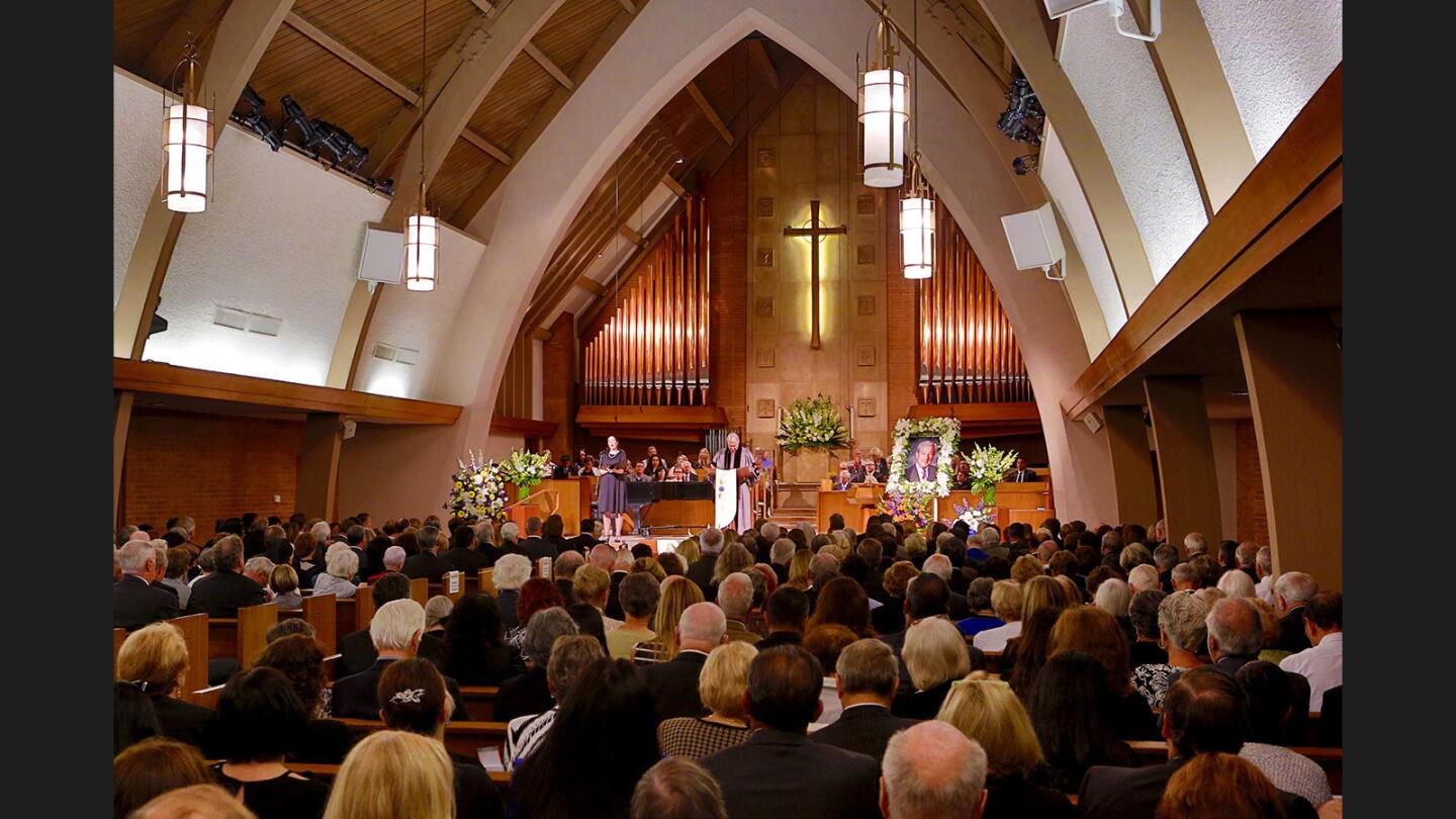 Rev. Chuck Osburn stands at center as soloist Rebecca Sjowall, left, performs at the end of memorial service for former La Cañada Flintridge mayor Dave Spence.
