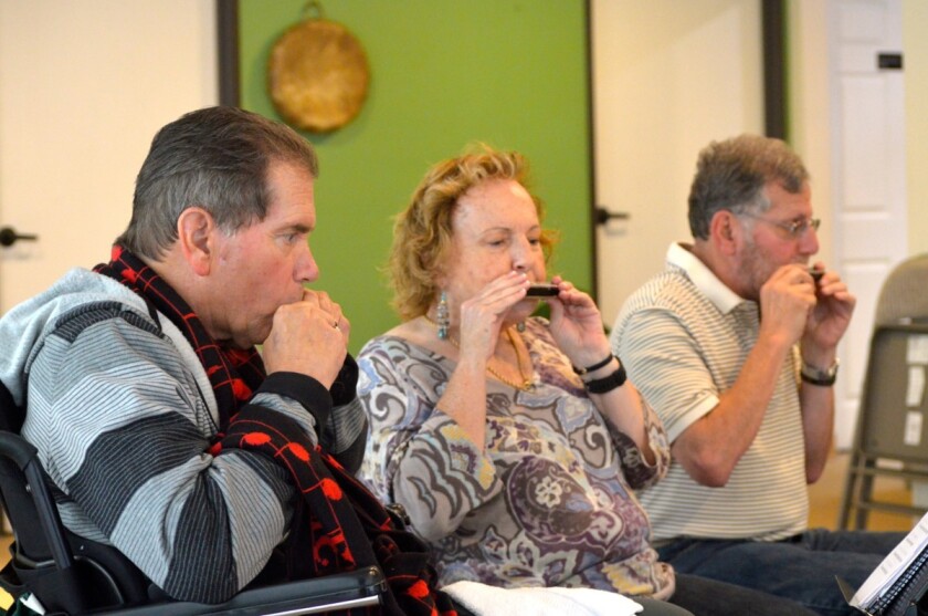 MusixWorx participants in a 12-week AudAbility program for people with Parkinson’s disease play the harmonica.