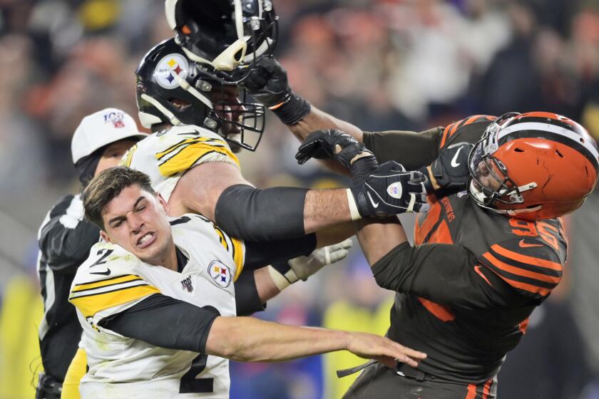 Browns defensive end Myles Garrett (95) hits Steelers quarterback Mason Rudolph (2) with a helmet during the second half of a game Nov. 14.