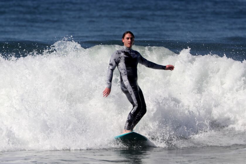 Los Angeles, CA - March 26: Lawrence Doherty catches a wave in Zuma Beach in the first part of the California Triple, on Sunday Mar. 26, 2023. The triple includes surfing, skateboarding and snowboarding in the same day. (Luis Sinco / Los Angeles Times)