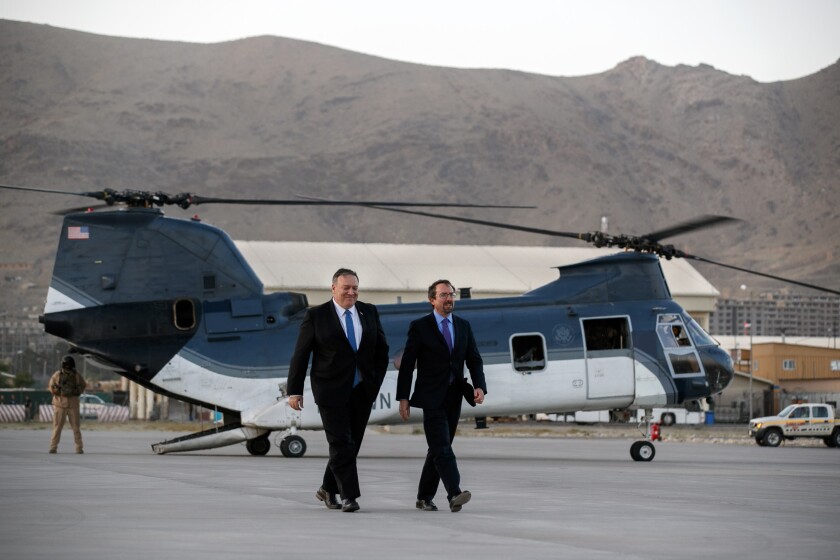 FILE - In this June 25, 2019 photo, Secretary of State Mike Pompeo, left, walks from a helicopter with U.S. Ambassador to Afghanistan John Bass. Bass is leaving Afghanistan, ending his two-year tenure as America's ambassador to the war-weary country that began in December 2017. (AP Photo/Jacquelyn Martin, Pool, File)