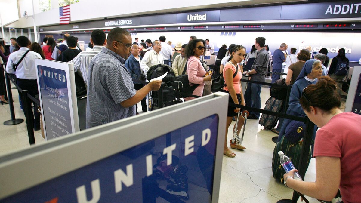 Passengers wait in line to check in at the United terminal at Los Angeles International Airport. United Airlines is testing a new way to board passengers on planes to reduce congestion and frustration.