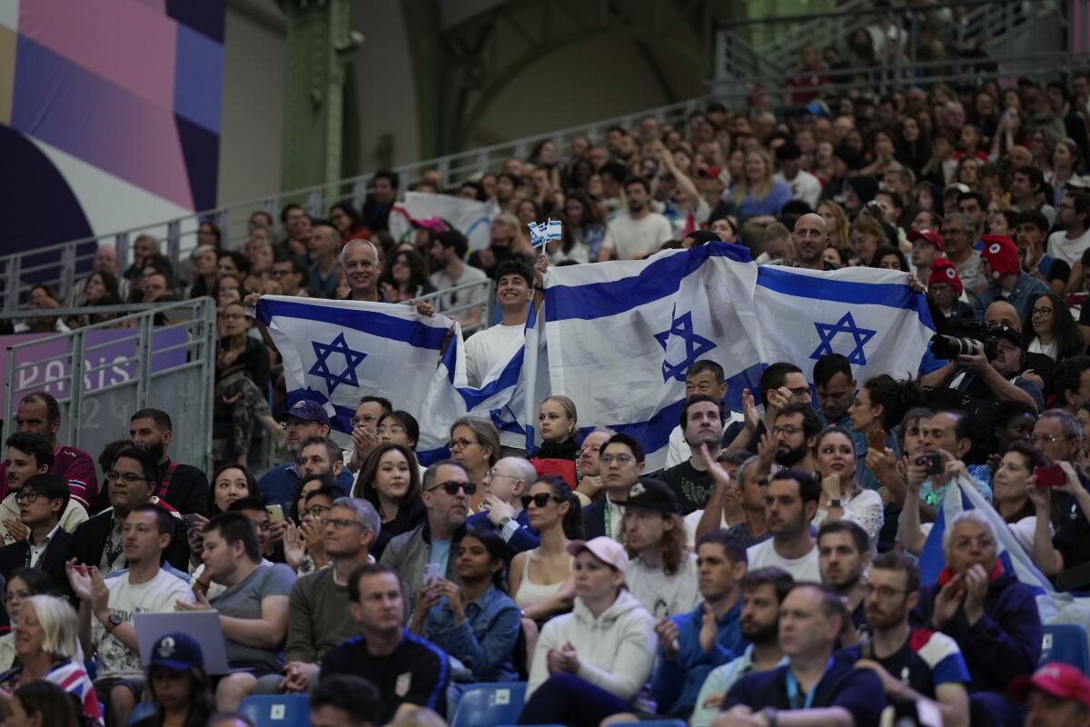 Fans hold Israel flags at the Olympics.