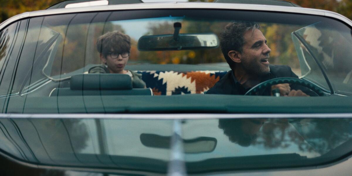 A boy and his father in a car on a road trip.