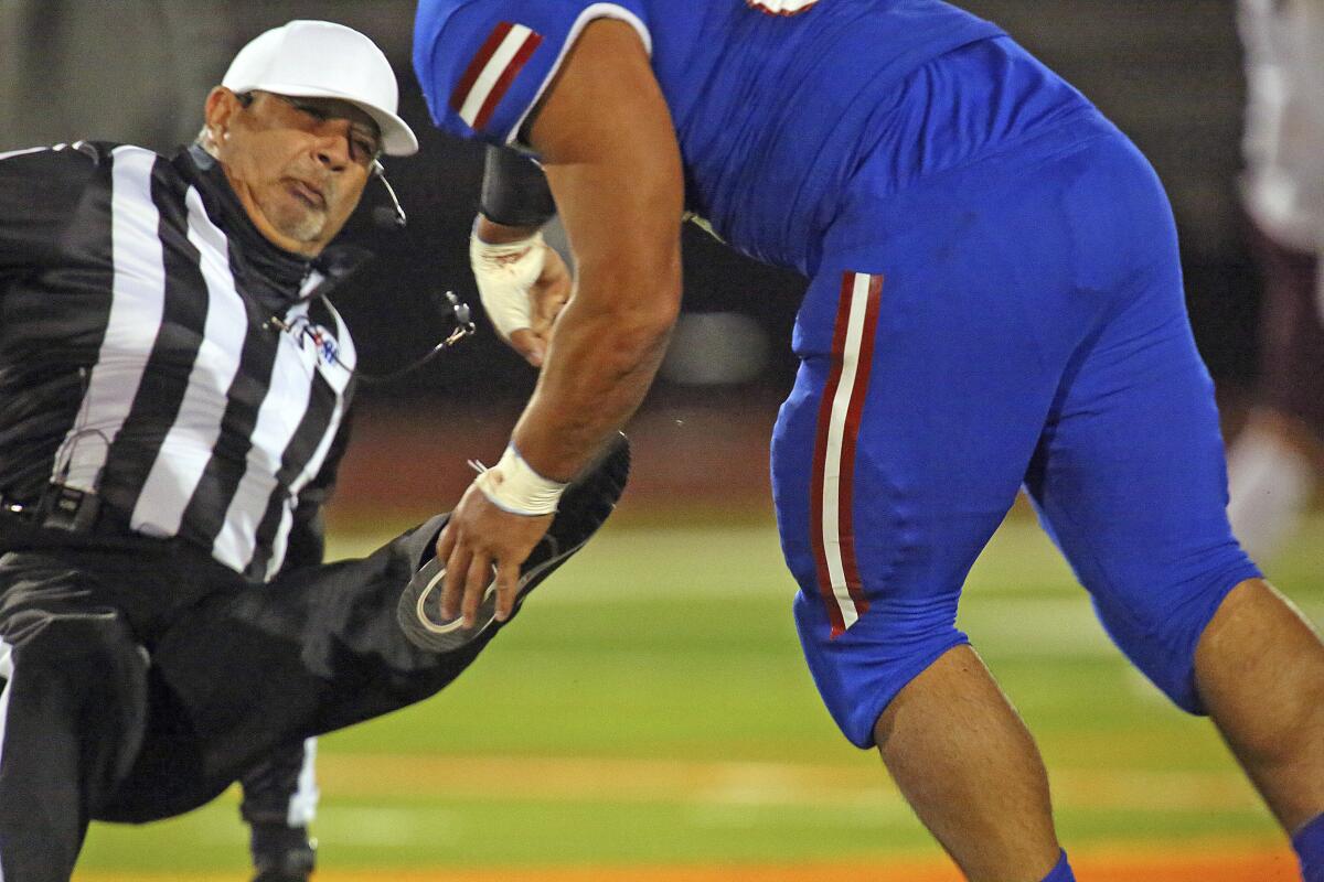 Referee Fred Gracia falls to the turf after being charged by Edinburg's Emmanuel Duron on Dec. 3 in Edinburg, Texas.