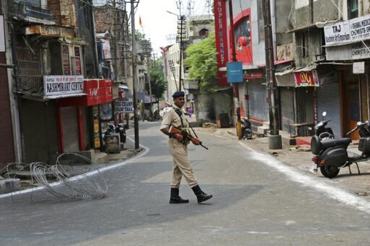An Indian paramilitary soldier stands guard near closed shops in Jammu, in India's Kashmir region. India has cracked down on the region, revoking its quasi-autonomous status.