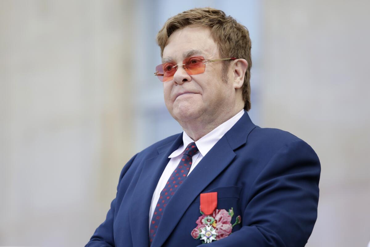 ARCHIVO – En esta fotografía del 21 de junio de 2019, Elton John en una ceremonia en su honor con la Legión de Honor en París. El concierto encabezado por Elton John, que incluyó a Billie Eilish y Alicia Keys, recaudó casi 8 millones de dólares para combatir el coronavirus. Se transmitió por Fox y las estaciones de radio de iHeartMedia. El dinero será para Feeding America y First Responders Children’s Foundation. La fundación Clara Lionel de Rihanna donará 1 millón para combatir el COVID-19 y la cifra será igualada por la fundación Shawn Carter de Jay-Z. La semana pasada la fundación de Rihanna donó 5 millones. (Foto AP/Lewis Joly, Pool, archivo)