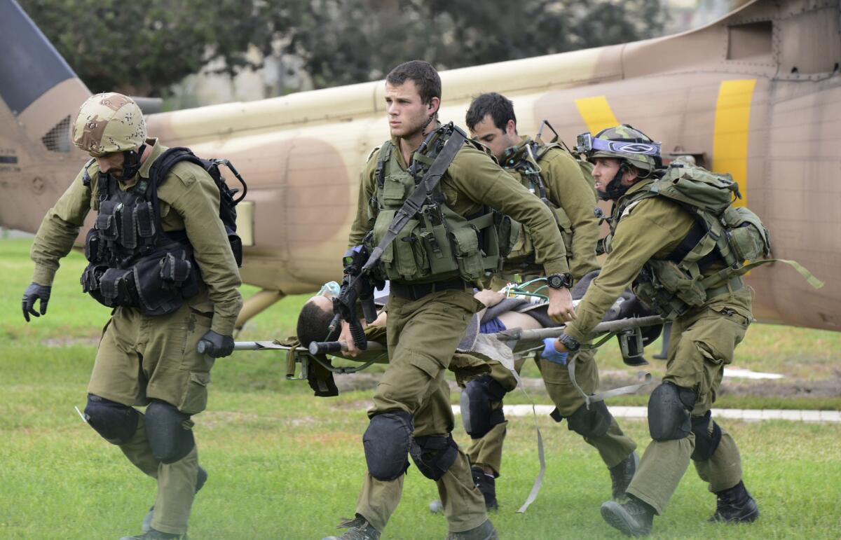 Israeli soldiers carry a comrade who was wounded in an attack on the border with Egypt to a hospital in Beersheba on Oct. 22.