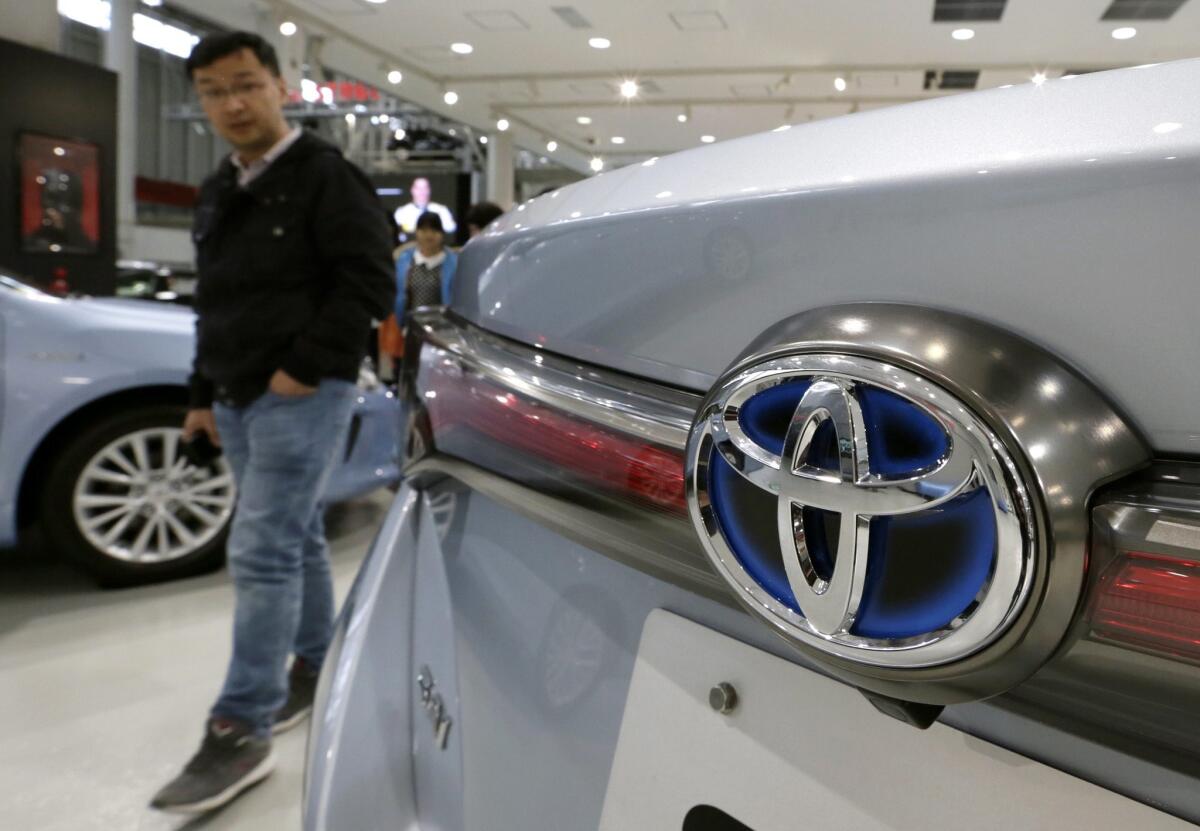 A man walks through Toyota Motor Corp.'s showroom in Tokyo. The automaker lifted its operating profit outlook for the year.