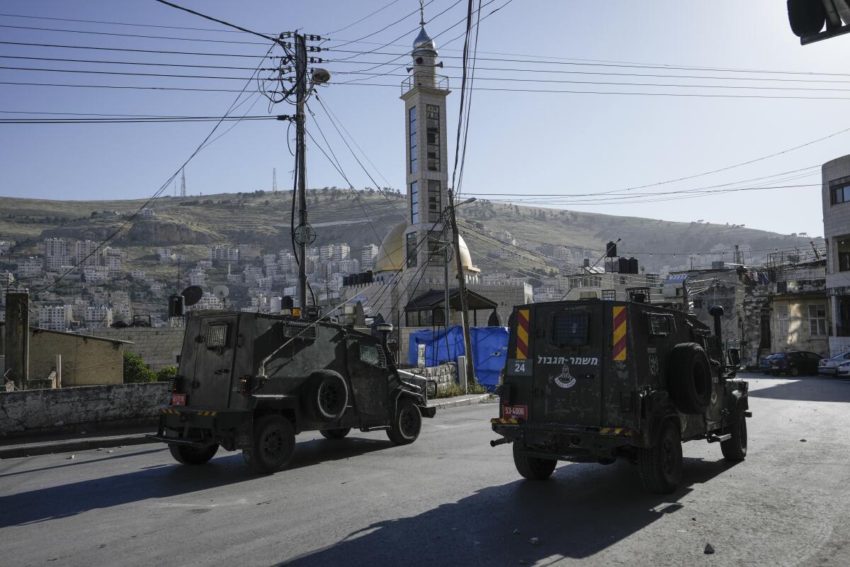 A convoy of Israeli military vehicles makes its way through the West Bank city of Nablus.