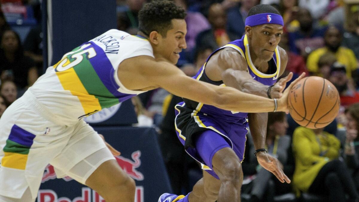 Pelicans guard Frank Jackson and Lakers guard Rajon Rondo try to chase down a loose ball during their game Saturday.