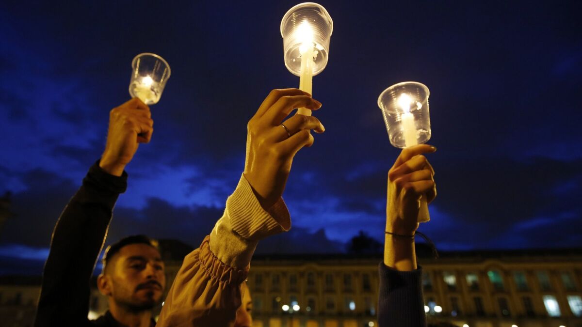 In this July 6 photo, demonstrators in Bogota, Colombia, hold up candles during a candlelight vigil for slain activists who have been killed since the signing of peace accords.