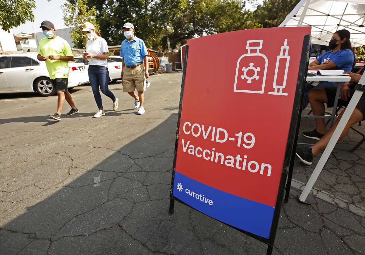 Three family members leave a COVID-19 vaccine clinic in Los Angeles after getting immunized.