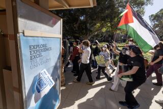 Los Angeles, CA - November 08: UCLA students march past an ad for a program at an Israeli university as they rally for Palestine on the UCLA campus in Westwood Wednesday, Nov. 8, 2023 in Los Angeles, CA. (Brian van der Brug / Los Angeles Times)