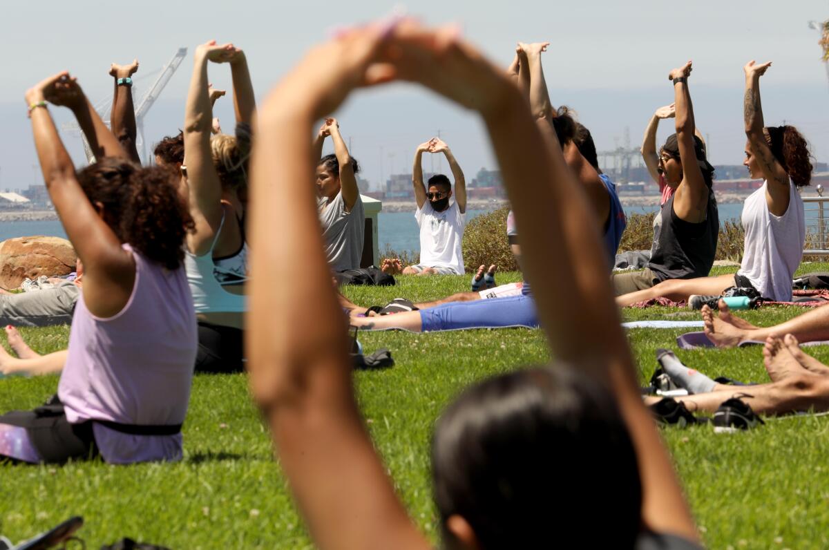 People participate in a session of, "Yoga on the Bluff," provided by Yogalution Movement along Ocean Blvd. on Sunday.