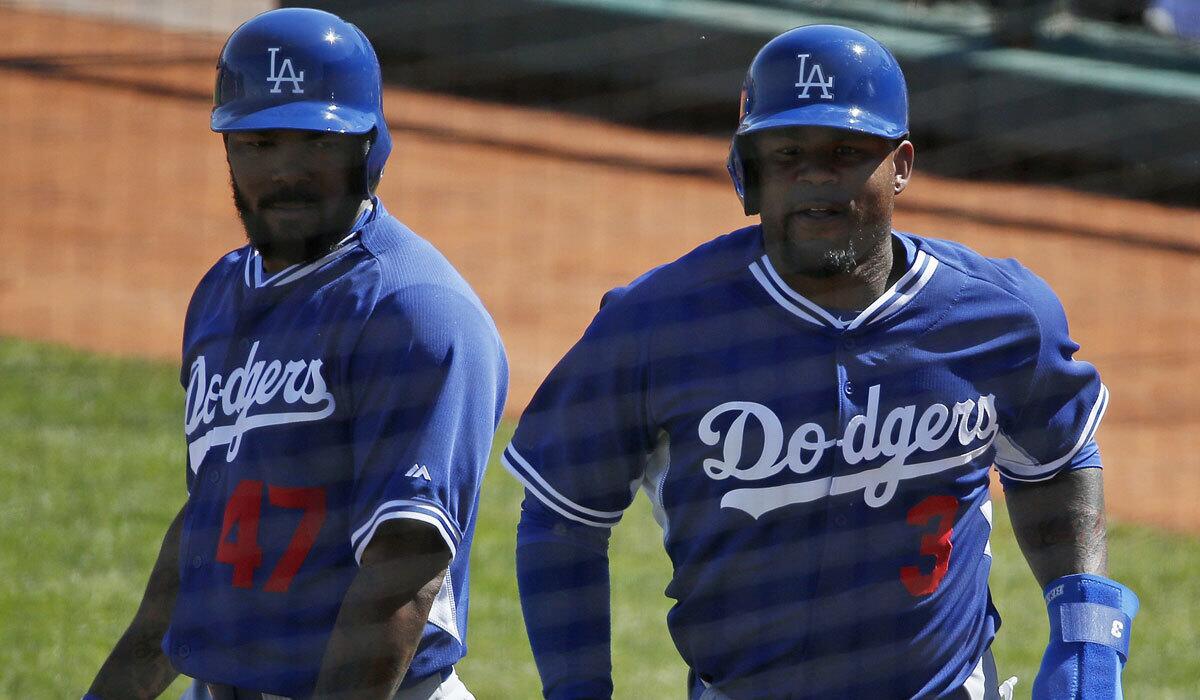 The Dodgers' Howie Kendrick, left, congratulates teammate Carl Crawford, who scored against the Cleveland Indians on Saturday.