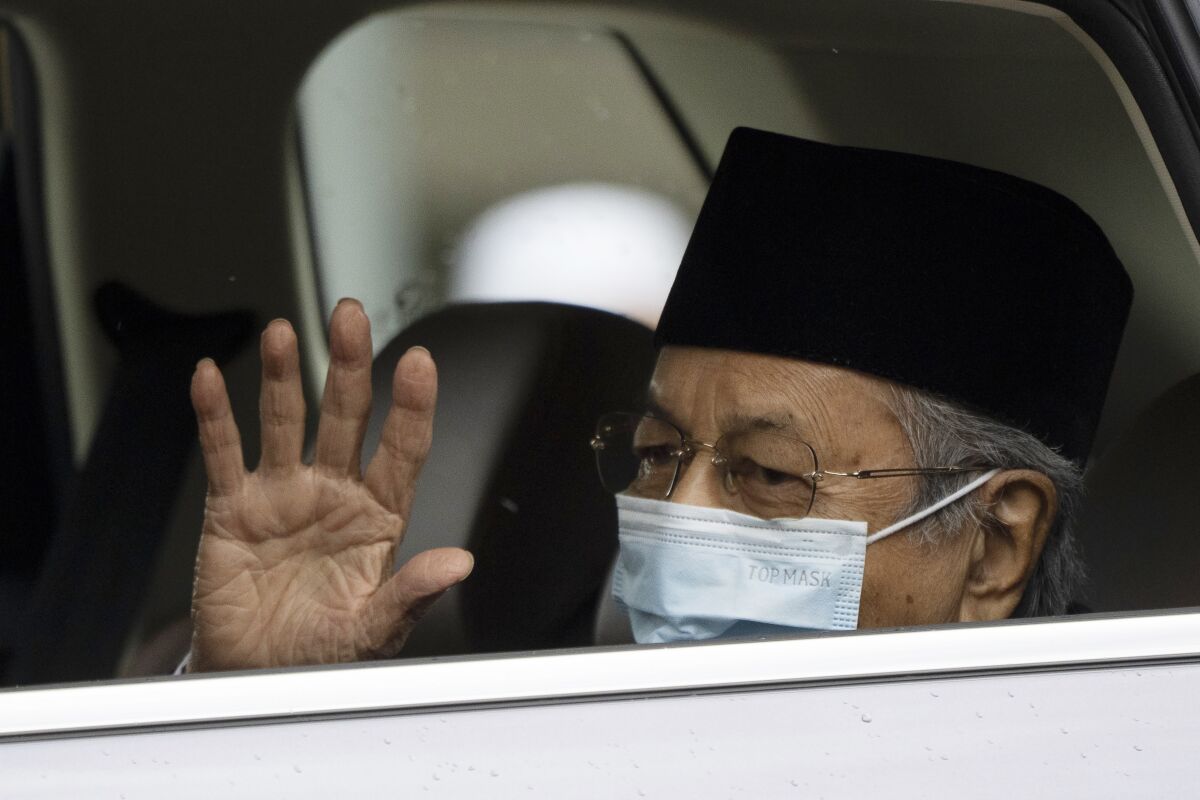 Malaysia's former Prime Minister Mahathir Mohamad, wearing a face mask, waves as he leaves the National Palace after meeting with the king in Kuala Lumpur, Malaysia, Thursday, June 10, 2021. (AP Photo/Vincent Thian)