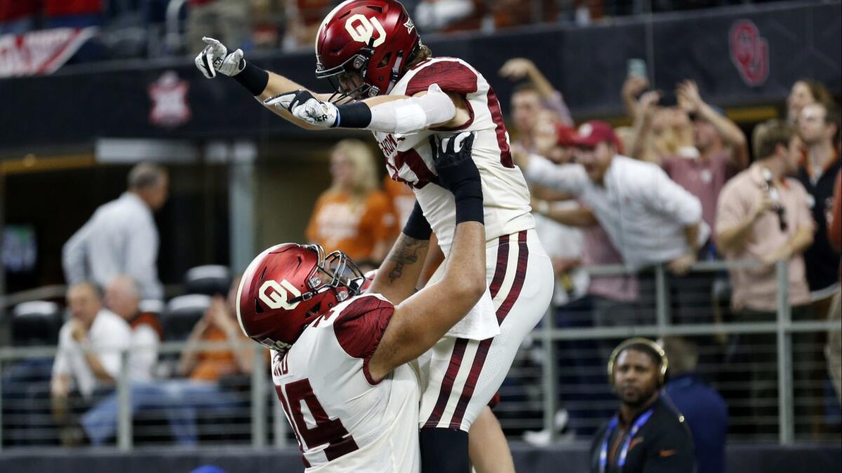 Oklahoma tight end Grant Calcaterra (right) celebrates a touchdown with offensive tackle Cody Ford (left) during the first half of the Big 12 Conference football championship against the Texas on Saturday.