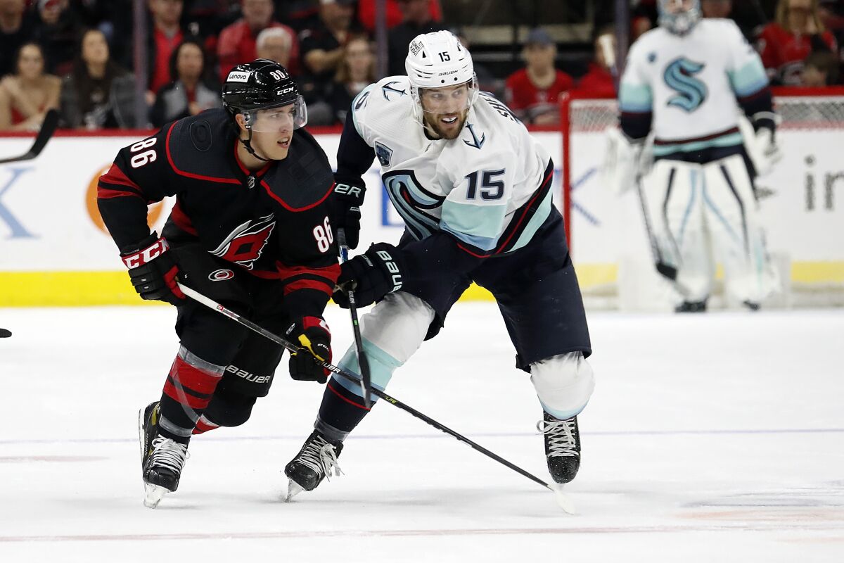 Carolina Hurricanes' Teuvo Teravainen (86) tangles with Seattle Kraken's Riley Sheahan (15) during the first period of an NHL hockey game in Raleigh, N.C., Sunday, March 6, 2022. (AP Photo/Karl B DeBlaker)