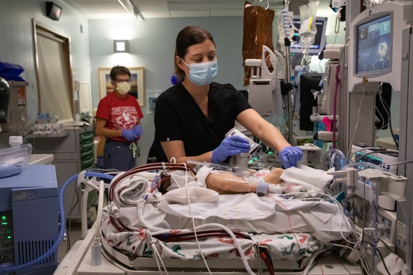San Diego, CA - December 22: Registered Nurses Lindsay Cousins (center) and Lisa Hayes (left) prepare a premature baby for a blood transfusion in the NICU department of Rady Children's Hospital in San Diego, CA on Thursday, Dec. 22, 2022. Newborns will be among the most threatened groups if an anticipated shortage of rare blood types materializes. (Adriana Heldiz / The San Diego Union-Tribune)
