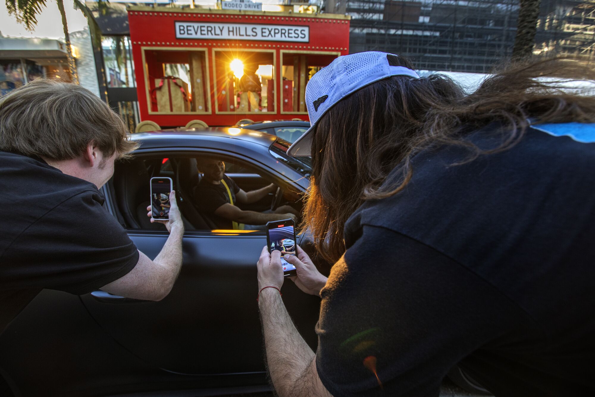 Daniel Macdonald and Blake Thompson use their iPhones to take video of a driver