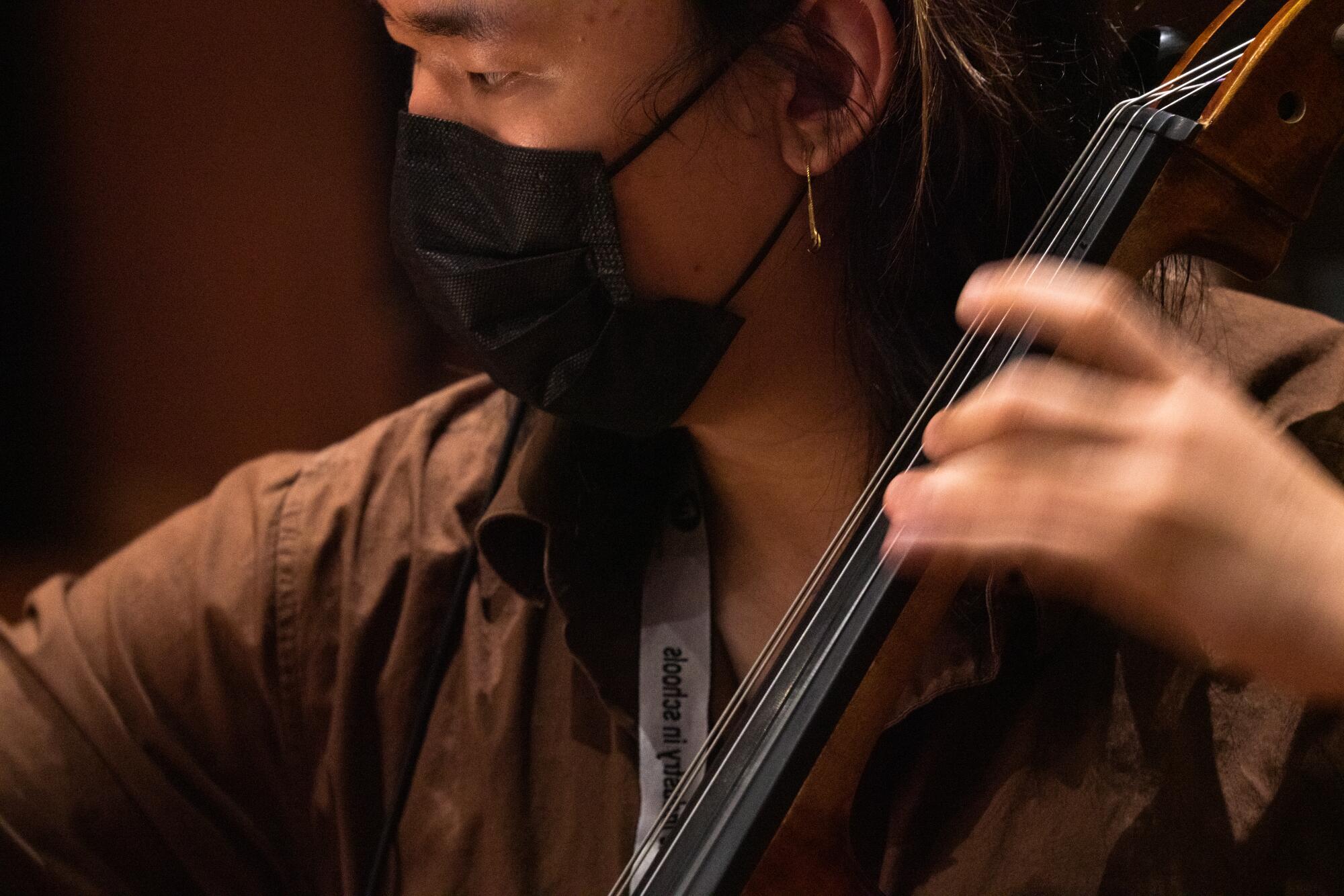 A student plays their string instrument.