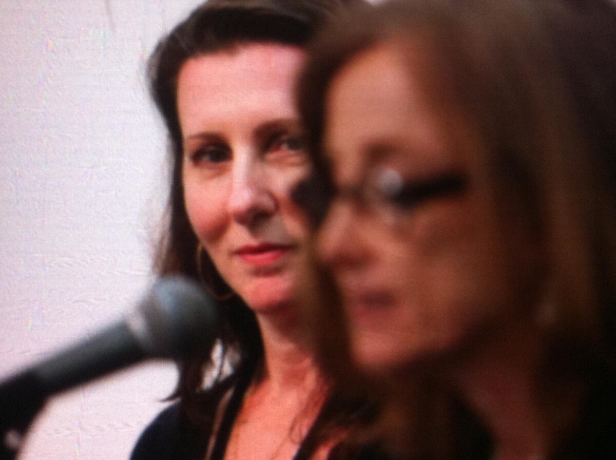 Author Bronwen Hruska, left, listens to Mona Simpson as she reads a poem about motherhood during a panel on the second day of the 2013 LA Times Book Festival.