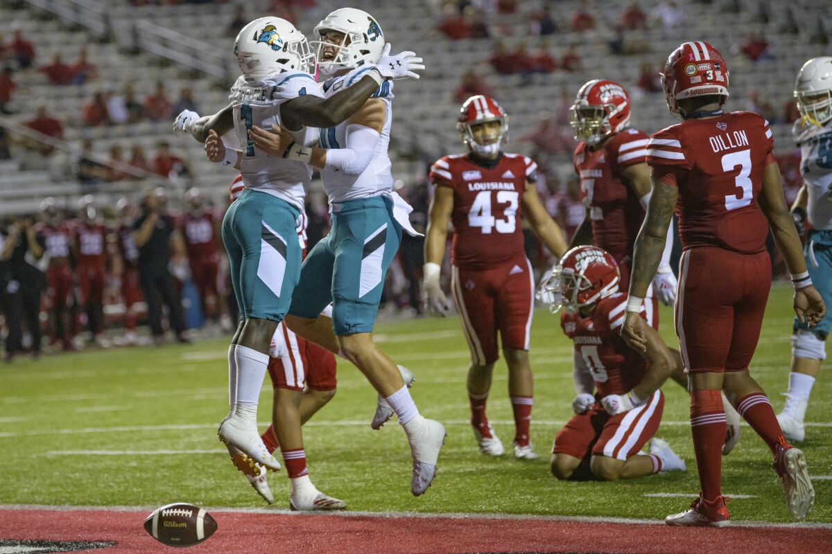 FILE - In this Oct. 14, 2020, file photo, Coastal Carolina running back CJ Marable (1) celebrates a touchdown with quarterback Grayson McCall (10) during an NCAA football game against Louisiana-Lafayette in Lafayette, La. Coastal Carolina coach Jamey Chadwell sees a new challenge for his surprising Chanticleers this fall: staying as hungry at chasing success as they were during their landmark 2020 season. Coastal Carolina is ranked No. 22 in the preseason this year, are not alone in the AP Top 25 with Louisiana-Lafayette right behind them at No. 23. It's the first time the league has had a pair of teams in the preseason rankings. (AP Photo/Matthew Hinton, File)