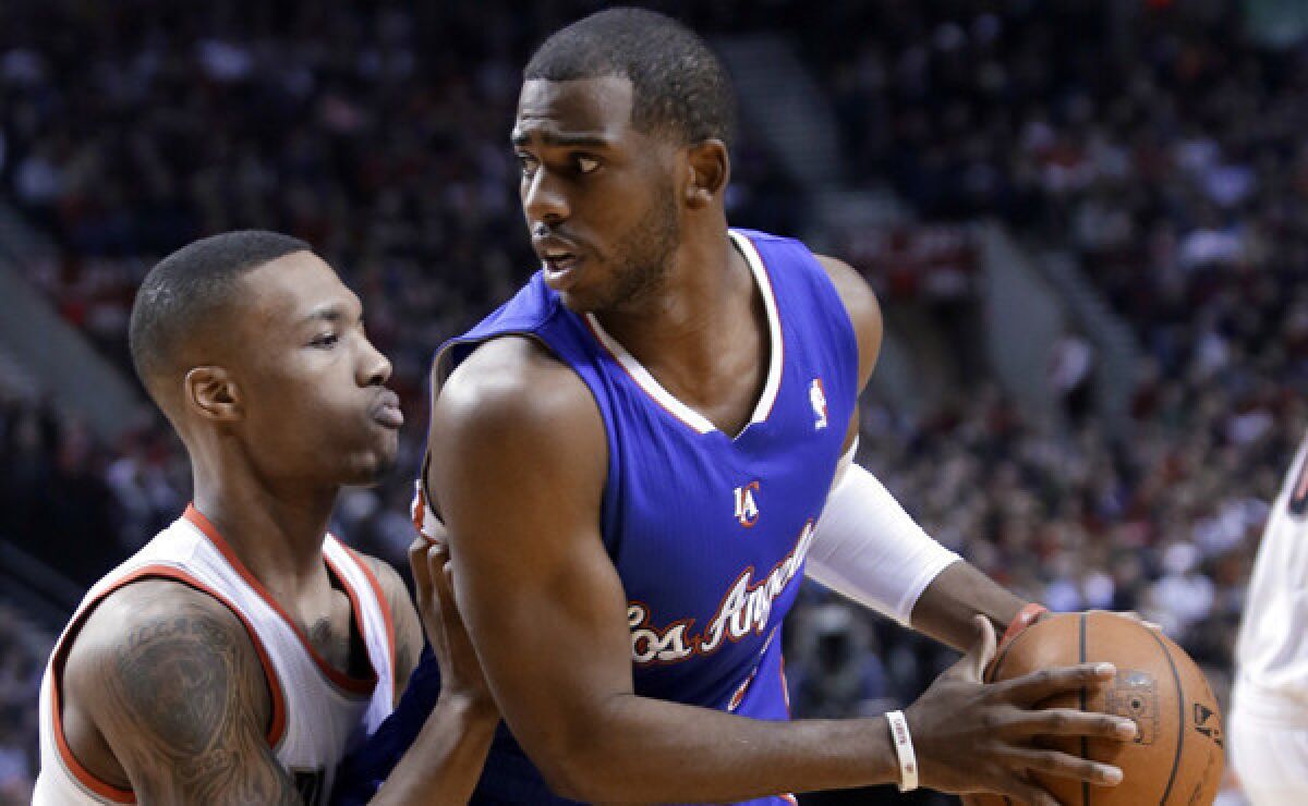 Clippers point guard Chris Paul, right, looks to get past Portland Trail Blazers guard Damian Lillard during a Dec. 26 Clippers loss. Paul doesn't know if he's ahead of schedule in his recovery from a right shoulder separation.