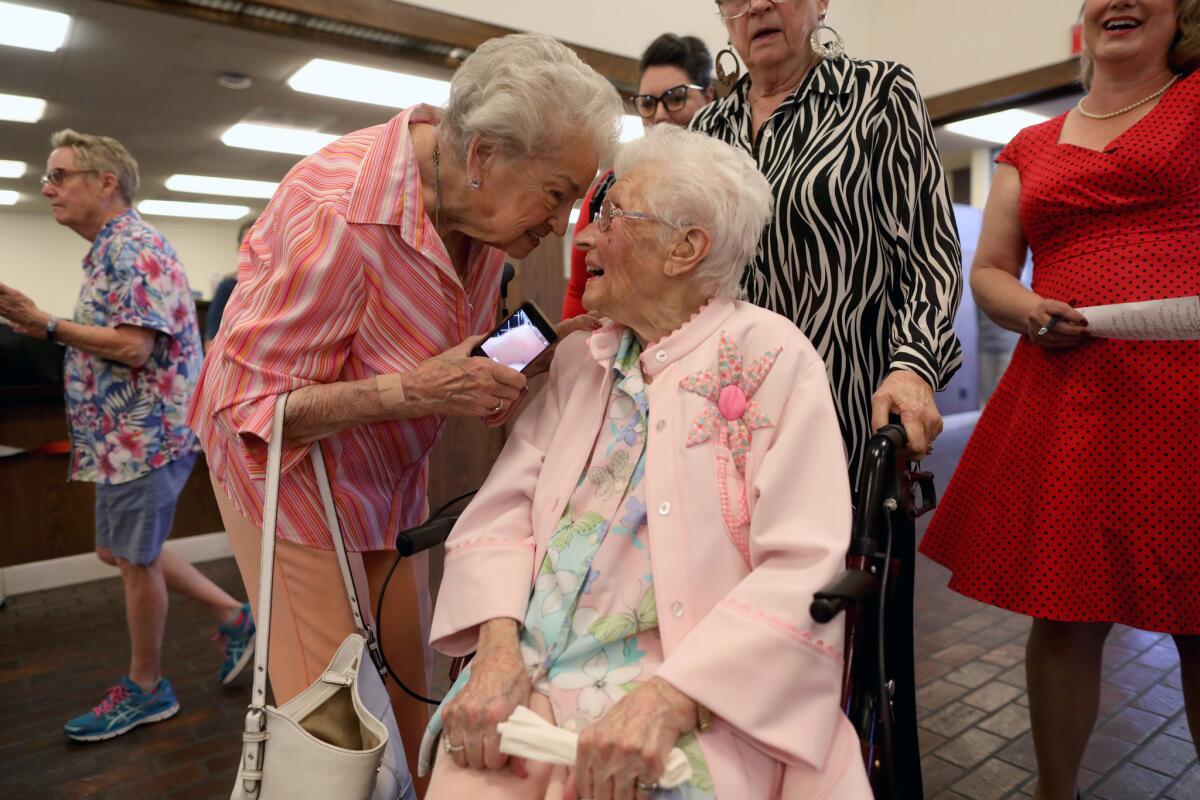 Irene Ekkens, 94, greets friend Opal Goode, seated, at her 112th birthday party at Bank of America in Ridgecrest. Opal came to California before the Dust Bowl.