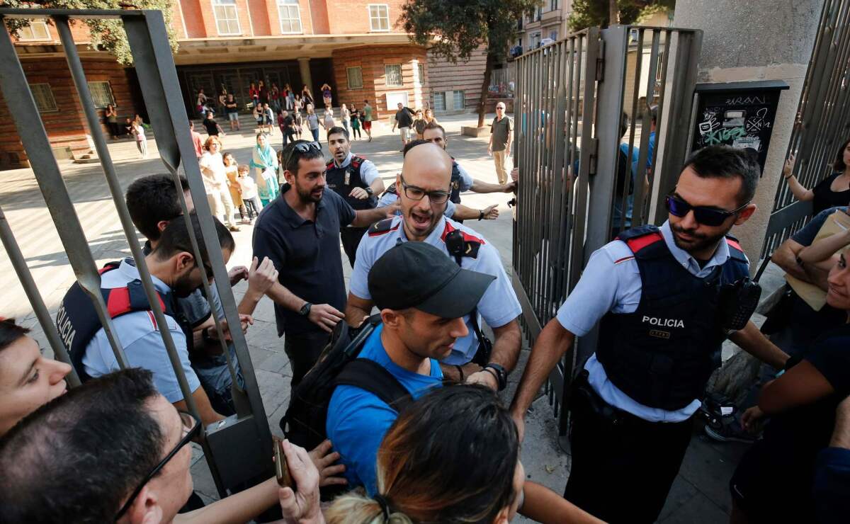 Police officers try stop referendum supporters from going into a school Friday in Barcelona. Pro-separatist Catalans occupied several Barcelona schools designated to be polling stations in a contested independence referendum to ensure the vote will go ahead.