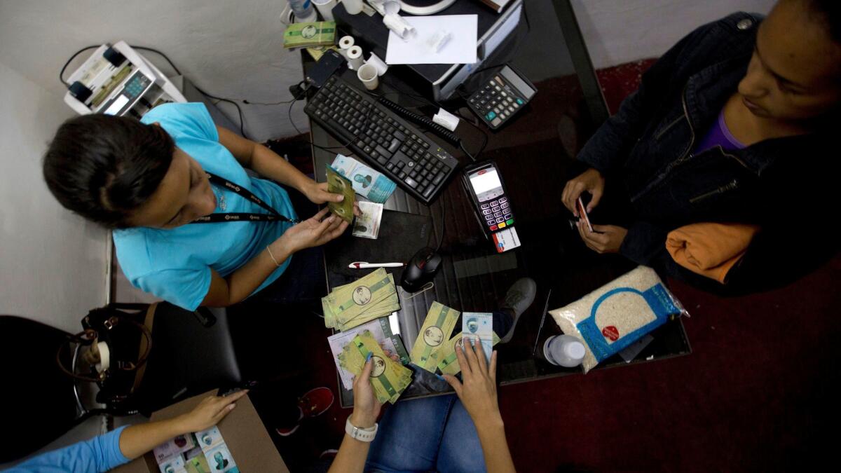 A customer buys bank notes at a communal bank in the 23 de Enero neighborhood of Caracas, Venezuela on Dec. 15.