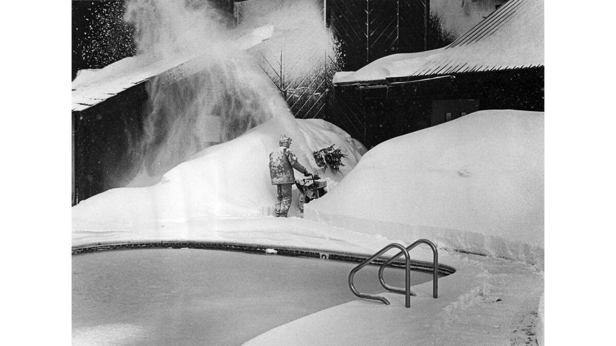 March 29, 1983: Sierra Nevada Inn manager Jim LeFeber clears a path near a swimming pool in a record snow year at Mammoth Lakes.